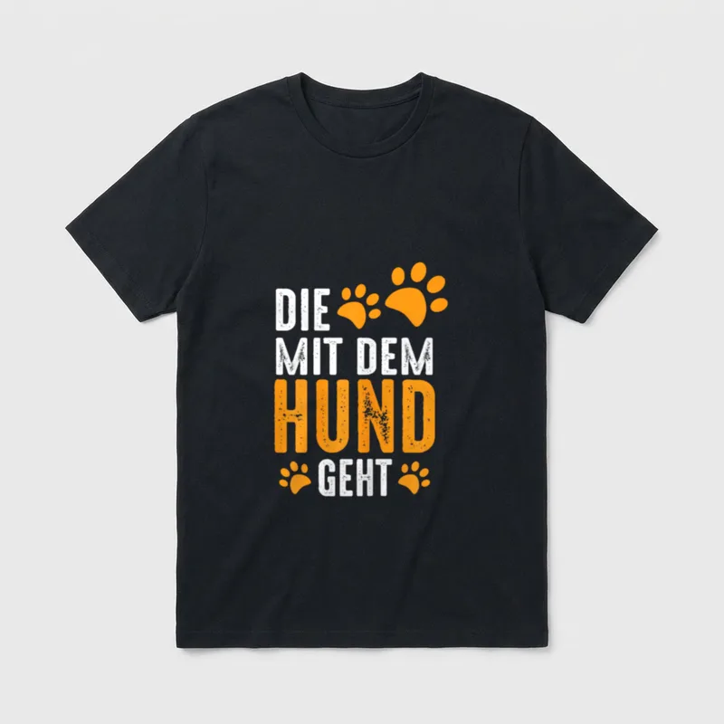 Hundemotiv T-Shirt – Schriftzug Die mit dem Hund geht mit orangefarbenen Pfotenabdrücken – Klassisches T-Shirt in Schwarz